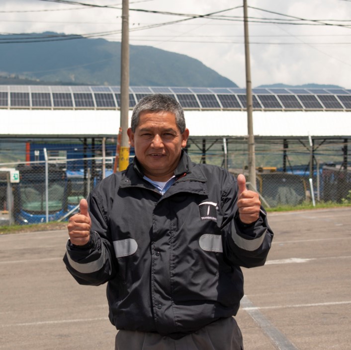 Operador de bus posando frente al área de mantenimiento del Patio El Uval